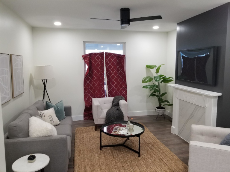Finished living room — fireplace, accent wall, recessed lighting