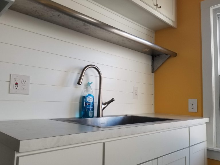 Larger sink basin with a stainless steel restaurant-style shelf from an architectural salvage store