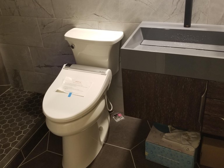 Bath vanity and toilet. Finished tile installation before door