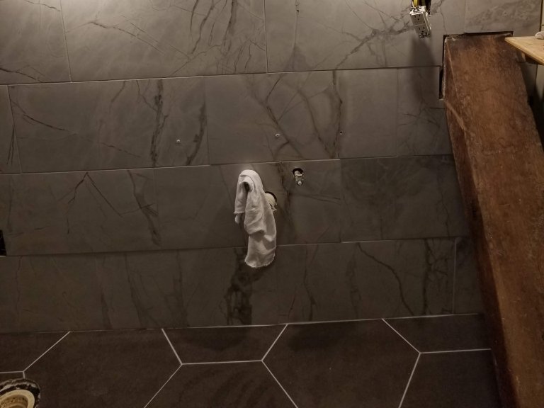 Bath tile installed behind floating vanity